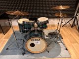 a drum set that is sitting on a rug in front of a microphone
