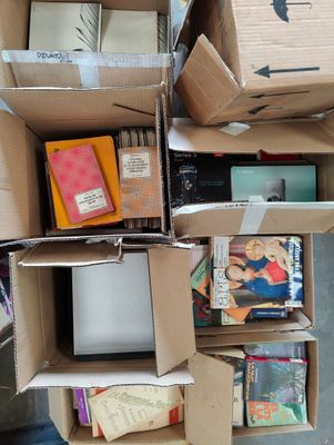 des cartons empilés les uns sur les autres dans une pièce remplie de livres