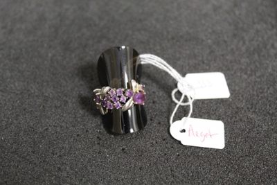 une bague en argent sertie de pierres violettes, avec une étiquette de prix