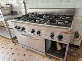 a stainless steel stove top in a kitchen with tile flooring