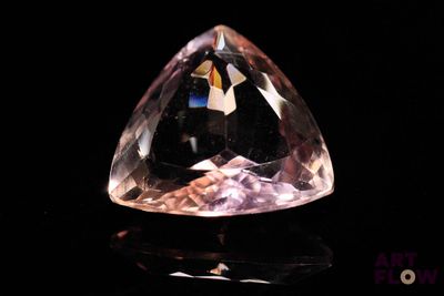 an image of a very pretty pink diamond on a black surface