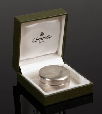 a silver ring in a green box on a black surface