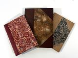 three different types of notebooks sitting on top of a white surface