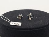 une paire de boucles d'oreilles en argent dans un coffret noir muni d'une étiquette