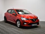 une voiture rouge est garée dans une pièce au sol en damier
