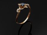 une image d'une bague en or avec une pierre bleue au centre