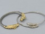 pair of silver and gold bracelets with two birds on them