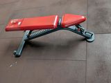 a red bench sitting on the floor in a gym