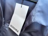 the back of a blue shirt with a tag on it