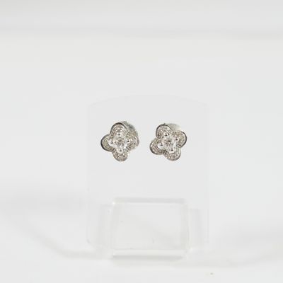 une paire de boucles d'oreilles en diamant posées sur un présentoir transparent