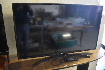 une télévision à écran plat posée sur une table en bois