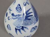a blue and white vase with a bird on it
