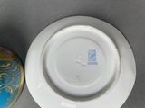 a blue and gold vase next to a blue and white plate
