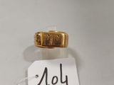 une image d'une bague en or sur une surface blanche avec une étiquette de prix