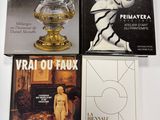 trois livres posés sur une table sur laquelle se trouve un vase