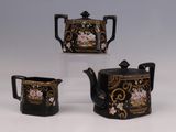 trois théières ornées de motifs noirs et dorés, posées sur un fond blanc