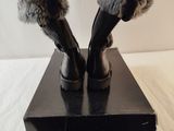 pair of black leather boots with fur cuffs on a black box