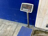a scale on the ground next to a blue wall
