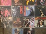 many different album covers on the wall of a room