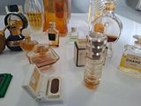many different perfume bottles on a table with a mirror