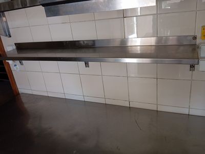 a stainless steel shelf in the middle of a kitchen