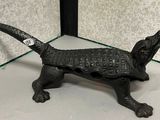 une figurine représentant un chien noir, posée sur une étagère en verre