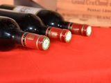 three bottles of wine sitting on a red table cloth