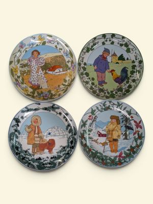 quatre assiettes sur lesquelles figurent des images de personnes et d'animaux, sur un fond blanc