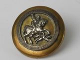 une image représentant un bouton en or orné d'un cheval et d'un cavalier