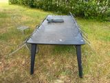 a table and chairs in the grass with a laptop on it