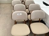 Plusieurs chaises sont alignées en rangée, avec une table en arrière-plan.