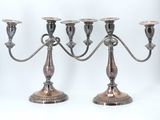 three silver candlesticks on a white background