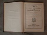 un livre ouvert sur lequel figure un blason