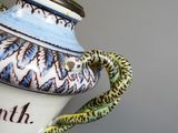 un vase bleu et blanc surmonté d'un serpent