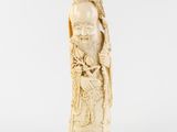 une figurine ancienne en ivoire sculpté représentant un homme tenant un oiseau