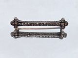 a close up of a pair of silver hair clips on a white surface