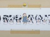 a picture of a child standing in front of a herd of cows