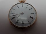 a gold pocket watch with roman numerals on the face