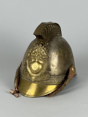 un vieux casque orné d'une décoration dorée sur le côté