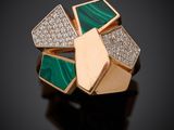 une image représentant une bague verte et dorée sertie de diamants, posée sur un fond noir