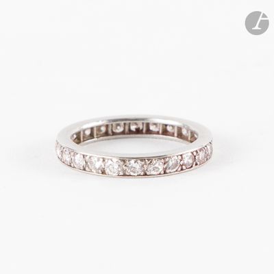 un gros plan d'une bague « éternité » sertie de diamants sur fond blanc