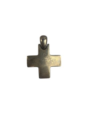 un gros plan d'une croix en métal sur fond blanc