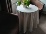 a small table with a potted plant on it in front of a window