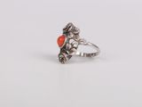 a close up of a silver ring with an orange stone