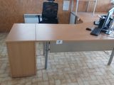 un bureau sur lequel se trouve un ordinateur, dans une pièce