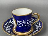 a blue and gold cup and saucer with a gold rim