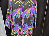 a colorful shirt hanging on a clothes rack in a room