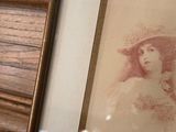 a picture of a woman in a hat on a dresser