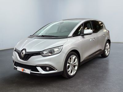 une voiture argentée garée dans une pièce blanche au sol noir