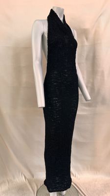 Le mannequin porte une robe noire à col claudine.
